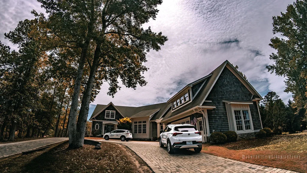 Suburban home with K's Cleaning Solutions vehicles in driveway — autumn day on the job